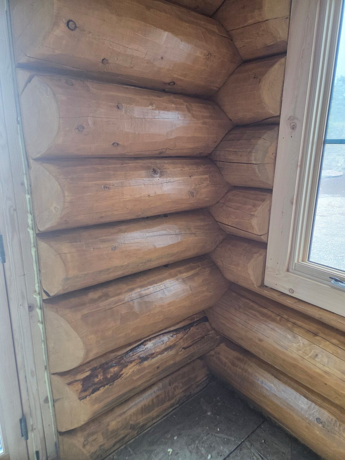 Stained round-timber log cabin interior by A1M Construction