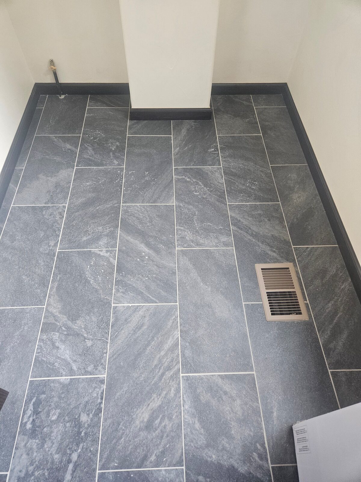 New dark gray rectangular floor tile with light grout